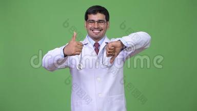 年轻英俊的波斯男医生在竖起大拇指和大拇指之间做出选择